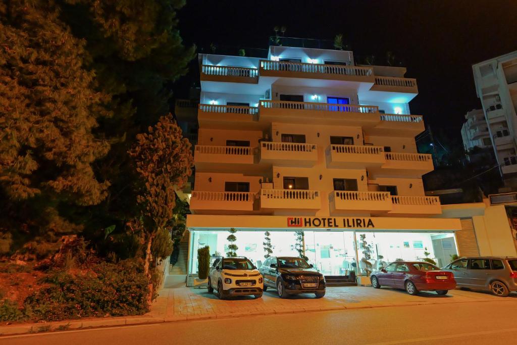 a large building with cars parked in front of it at Hotel Iliria in Sarandë