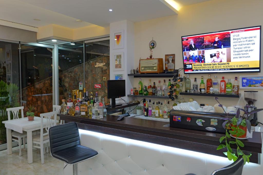 a bar in a restaurant with a tv on the wall at Hotel Iliria in Sarandë