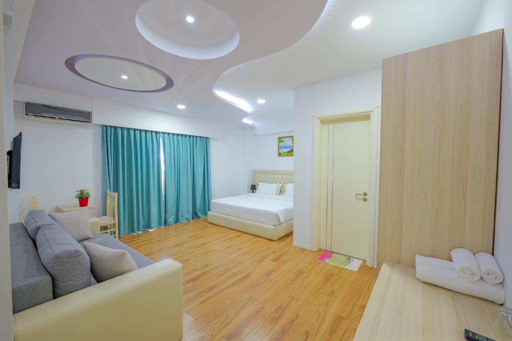 a living room with a couch and a bed at Hotel Iliria in Sarandë