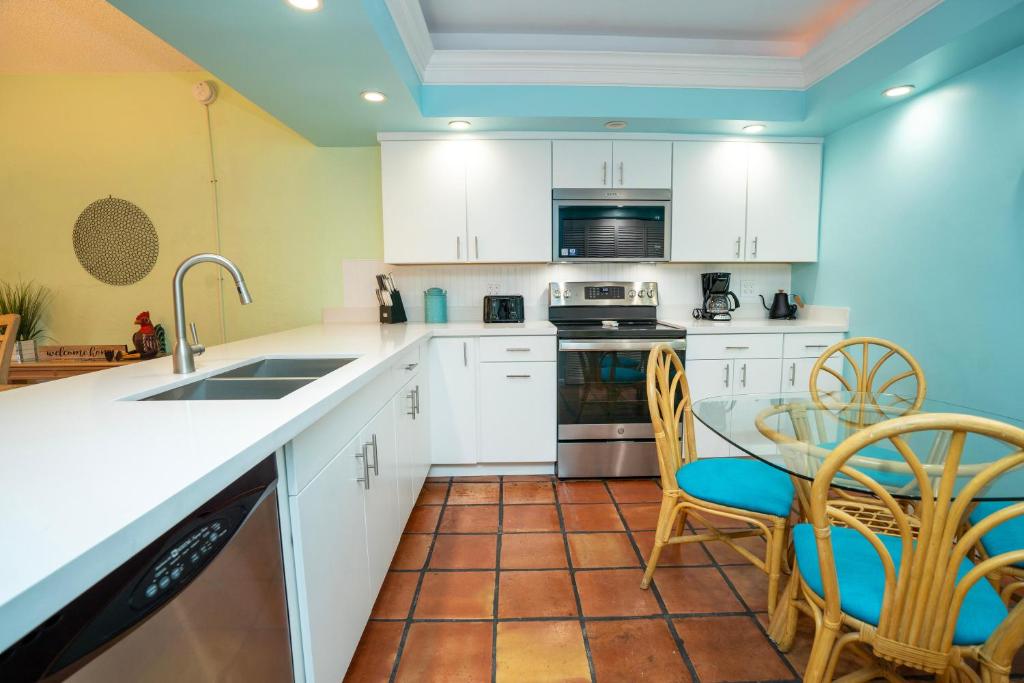 una cucina con armadi bianchi, tavolo e sedie di Nautical Adventures in Paradise a Key West