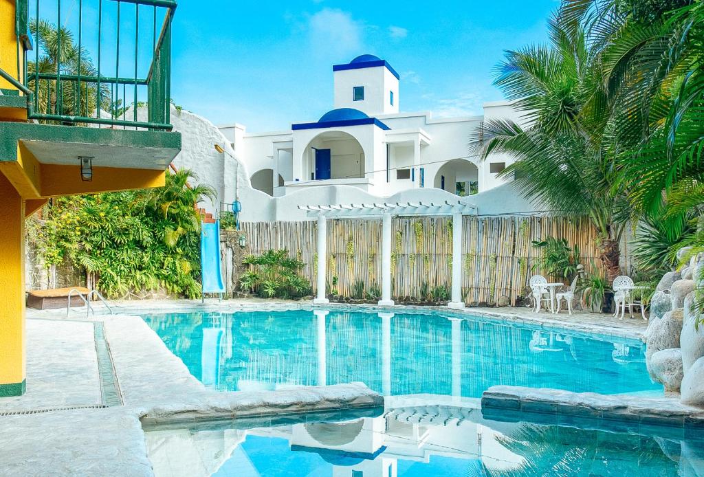 a swimming pool in front of a house at RedDoorz @ Yahweh Spring Retreat & Resort Laguna in Calamba