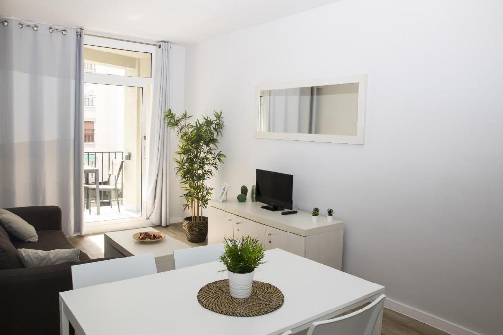 sala de estar blanca con mesa y TV en Sant Jordi Apartments Sagrada Familia en Barcelona