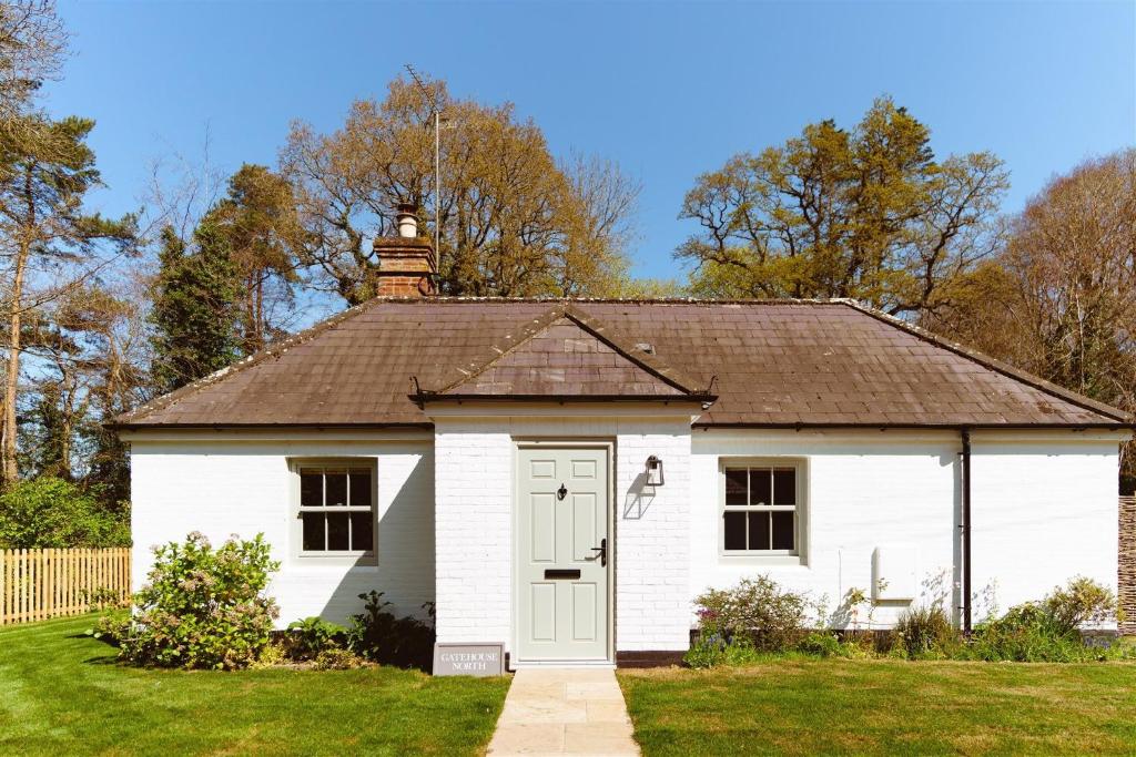 a small white house with a brown roof at Gatehouse North in Worstead