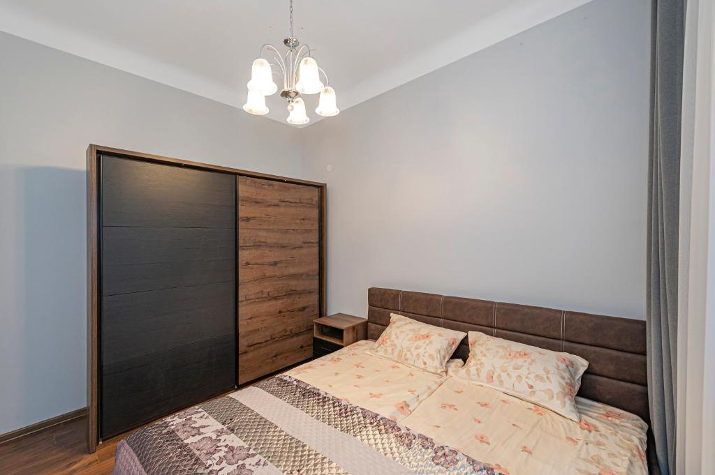 a bedroom with a large bed with a wooden headboard at Old town apartment with free parking by Polo Apartments in Kaunas