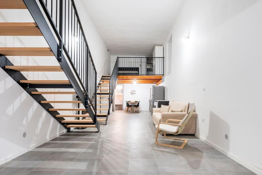 een woonkamer met een trap en een bank bij Appartamento al centro di Cagliari (Marina) in Cagliari