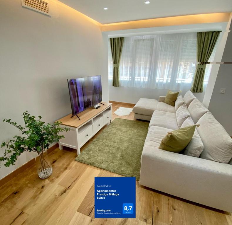 マラガにあるApartamentos Prestige Málaga Suitesのリビングルーム(白いソファ、テレビ付)