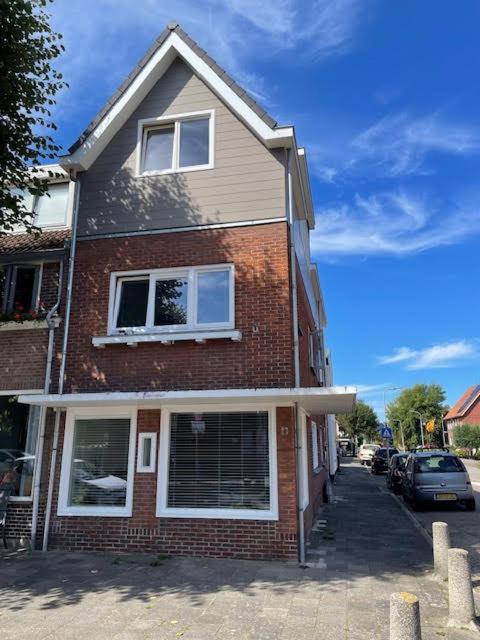 a brick house with two windows on a street at Duinroos vlakbij strand in Egmond aan Zee