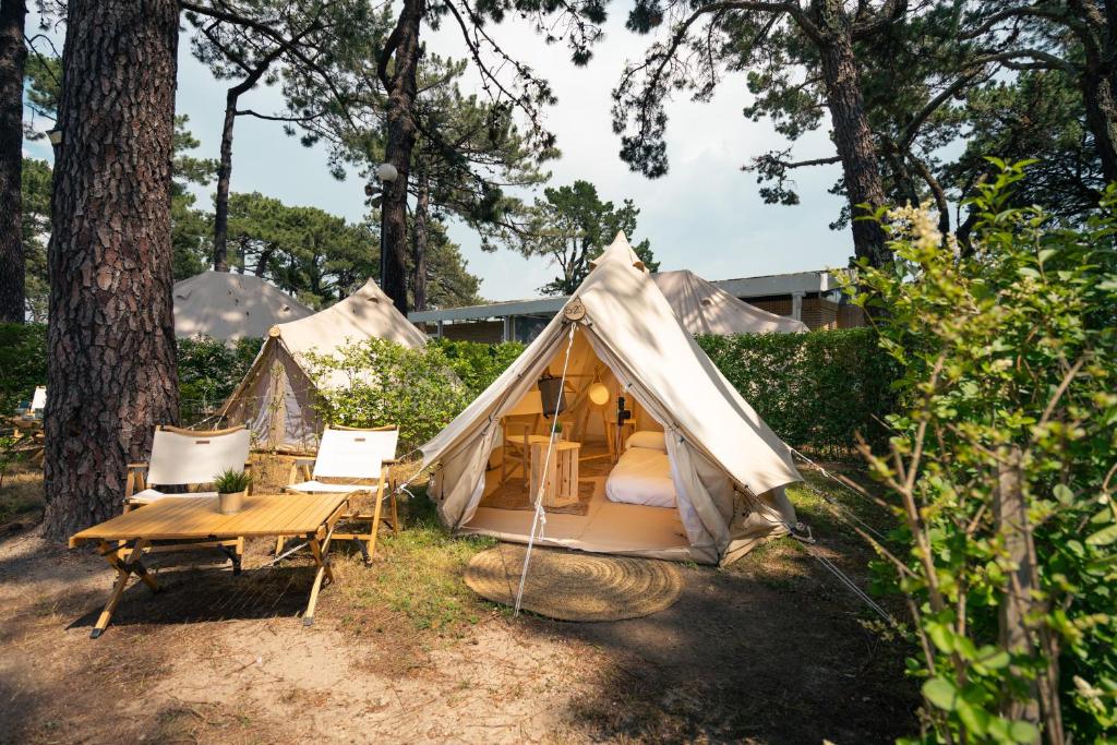 バイヨーナにあるKampaoh Bayona Playaの庭にテーブルと椅子が備わるテント