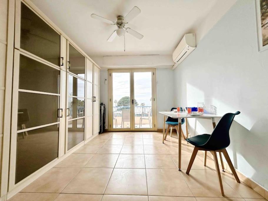 - un salon avec une table, des chaises et un ventilateur de plafond dans l'établissement Le Dulys : Apt 2 prs, vue mer, clim, 2 min plages, à Antibes