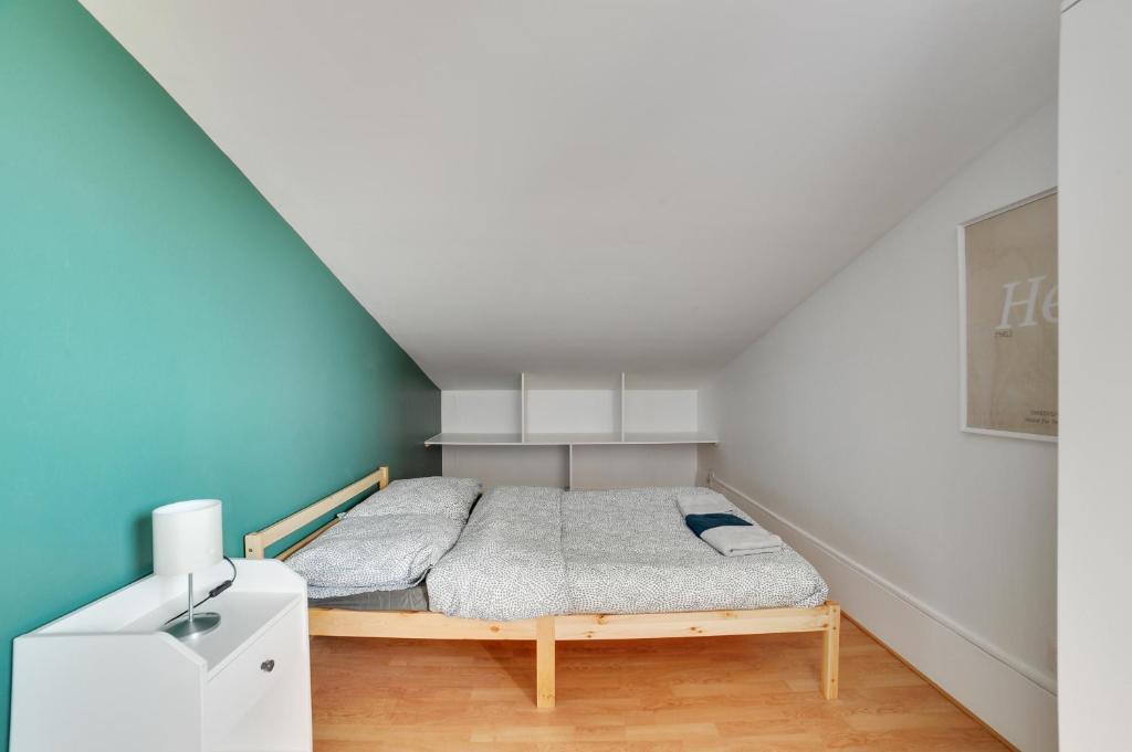 ein kleines Schlafzimmer mit einem Bett im Dachgeschoss in der Unterkunft Chic and spacious apart with parking in Paris in Pierrefitte-sur-Seine