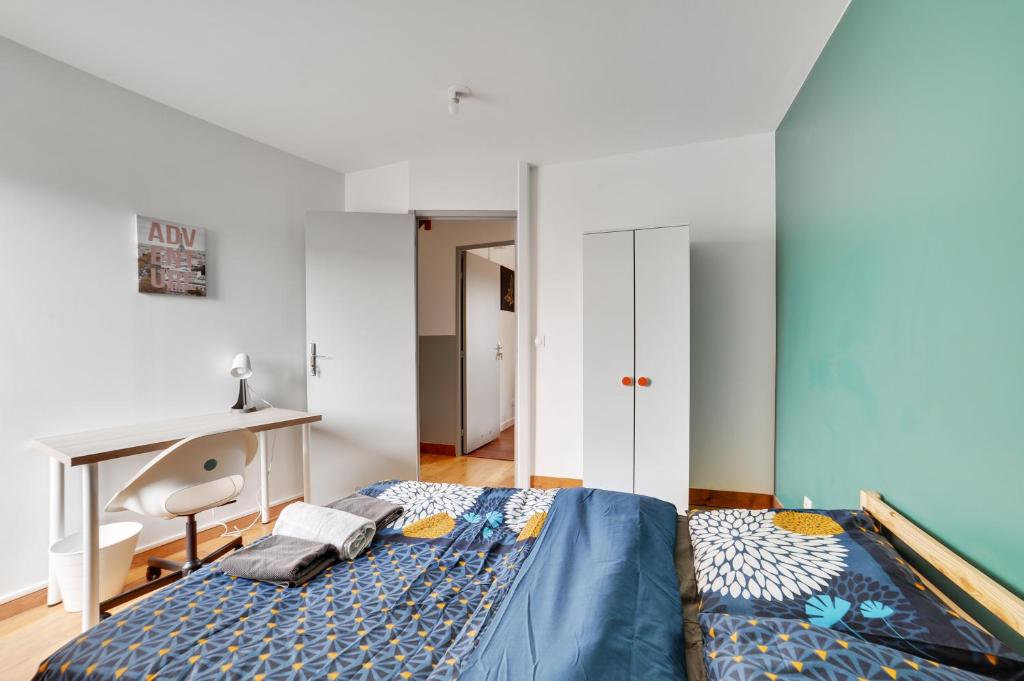Schlafzimmer mit einem Bett, einem Schreibtisch und einem Schreibtisch in der Unterkunft Chic and spacious apart with parking in Paris in Pierrefitte-sur-Seine