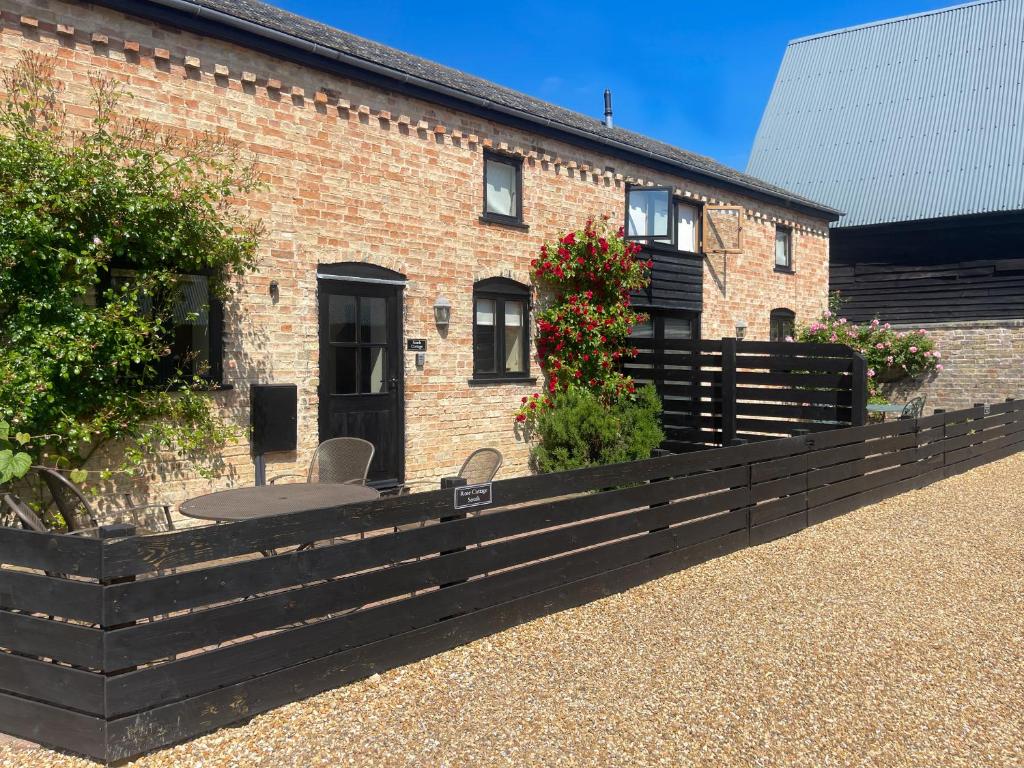 a brick house with a table and chairs in front of it at Pretty Cottage In Charming Peaceful Village - Easy Commute to Cambridge - Cambridge Homehost in Cambridge