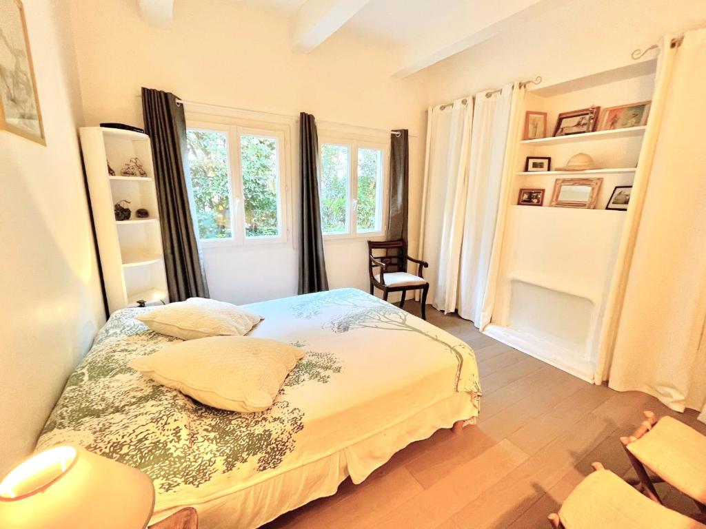 a bedroom with a bed and two windows at La Marjolette by Welcome to Cannes in Cannes
