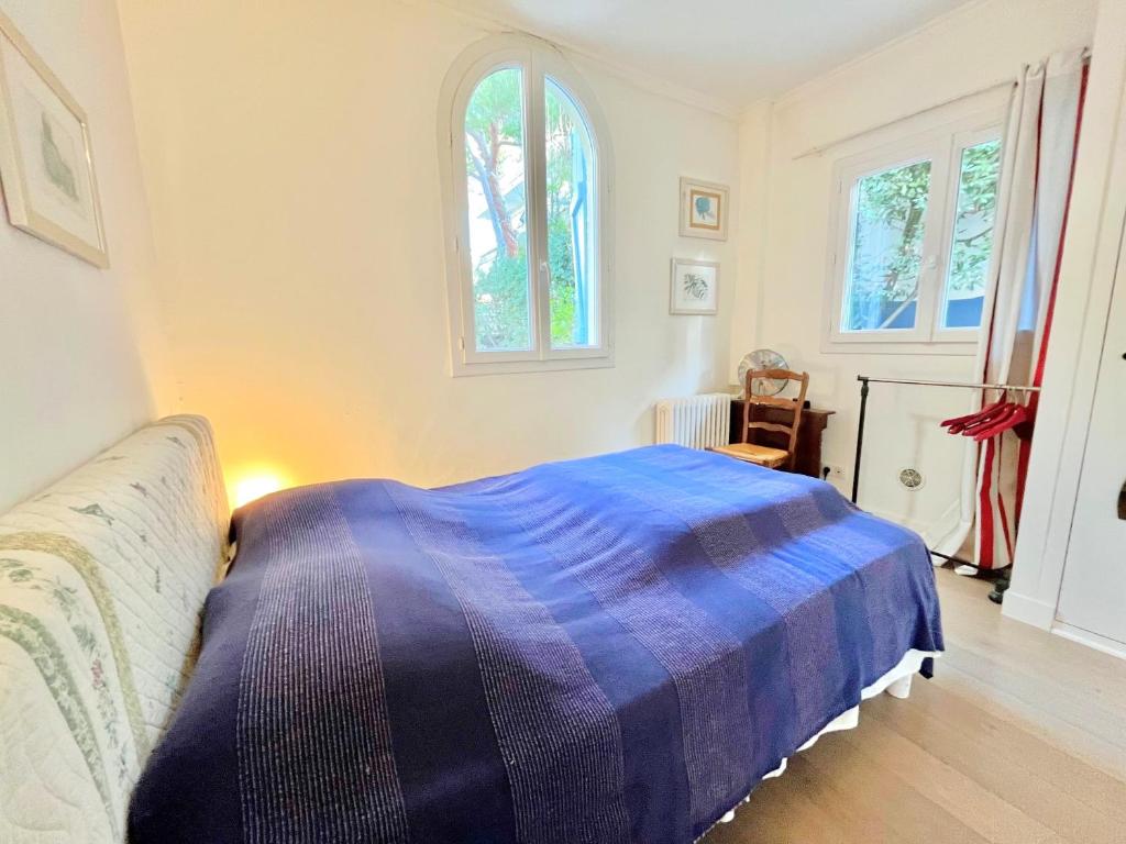 a bedroom with a bed with a blue blanket at La Marjolette by Welcome to Cannes in Cannes