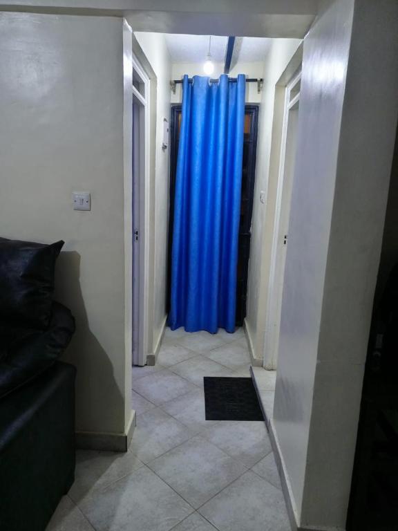 - un couloir avec un rideau bleu dans l'établissement SIFRA HOMES, à Nairobi