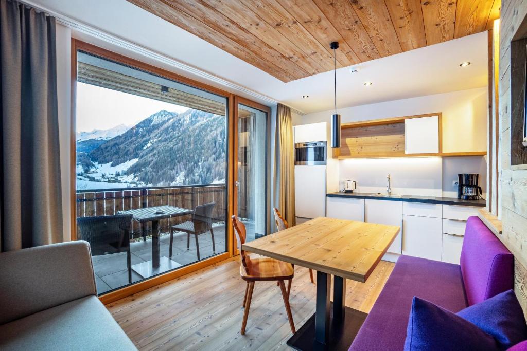 eine Küche und ein Esszimmer mit Bergblick in der Unterkunft Stoana Apt 1-1 in San Giacomo