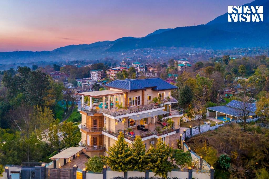 a home in the hills with a view of the city at StayVista at Address By The Khul in Dharamshala