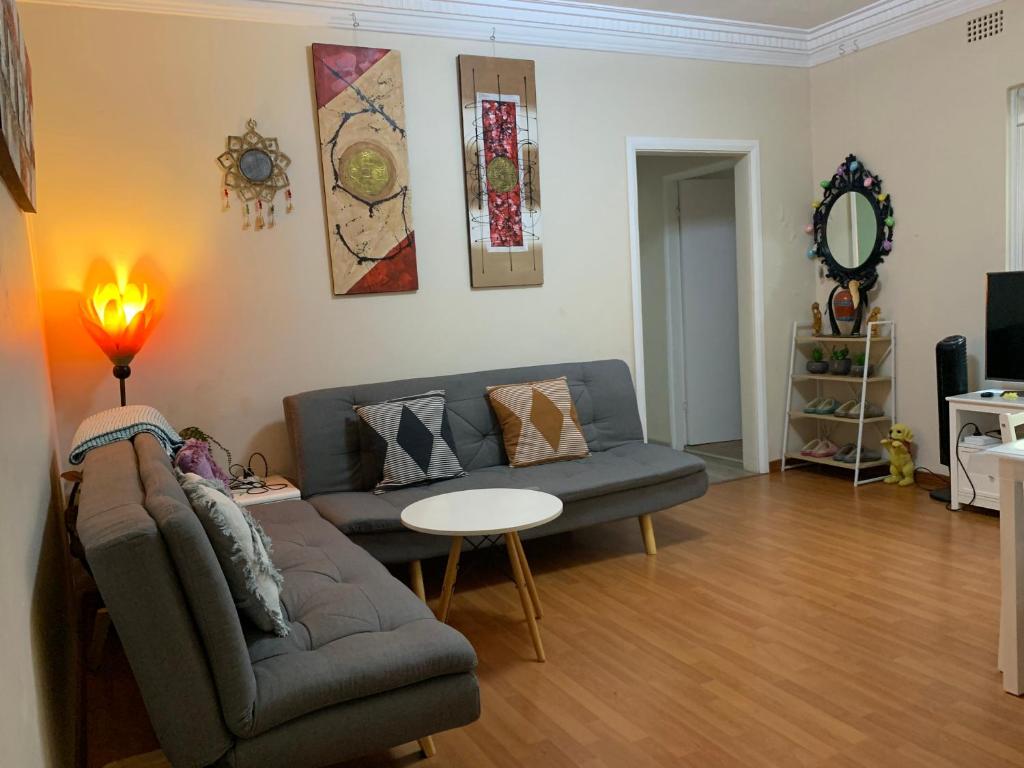een woonkamer met een bank en een tafel bij 2 bedroom small unit 1 minute walk to shopping centre NO PARKING SLOT in Wollongong