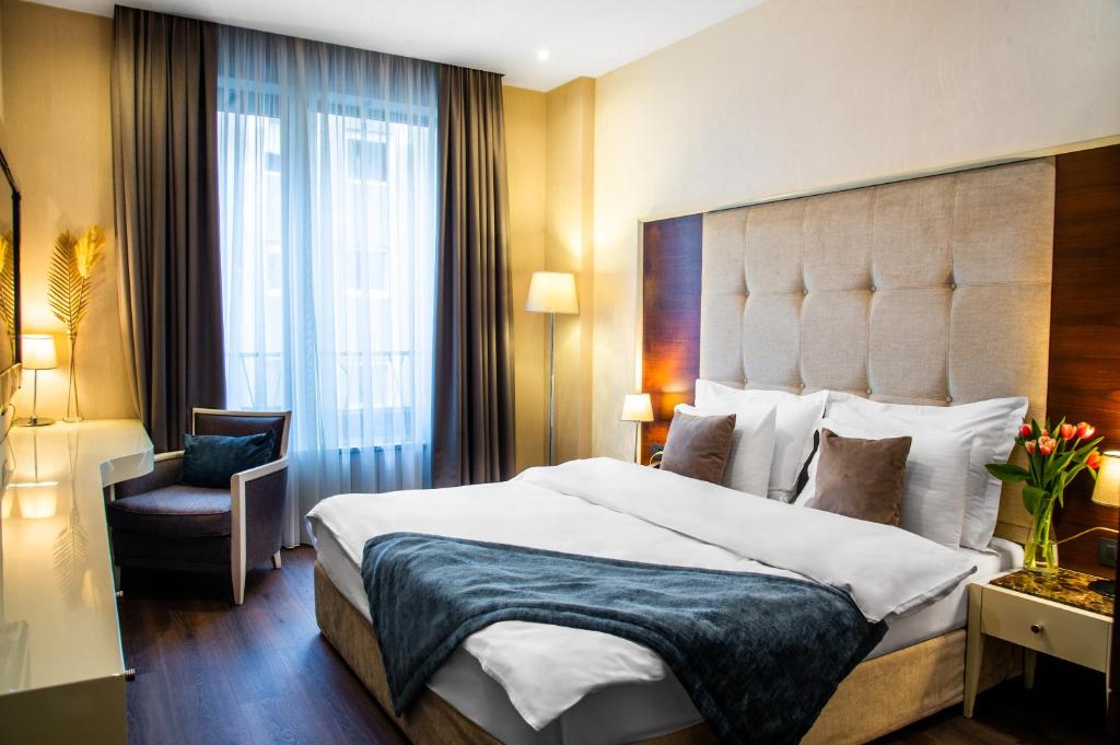 a hotel room with a large bed and a chair at Crystal Hotel in Belgrade