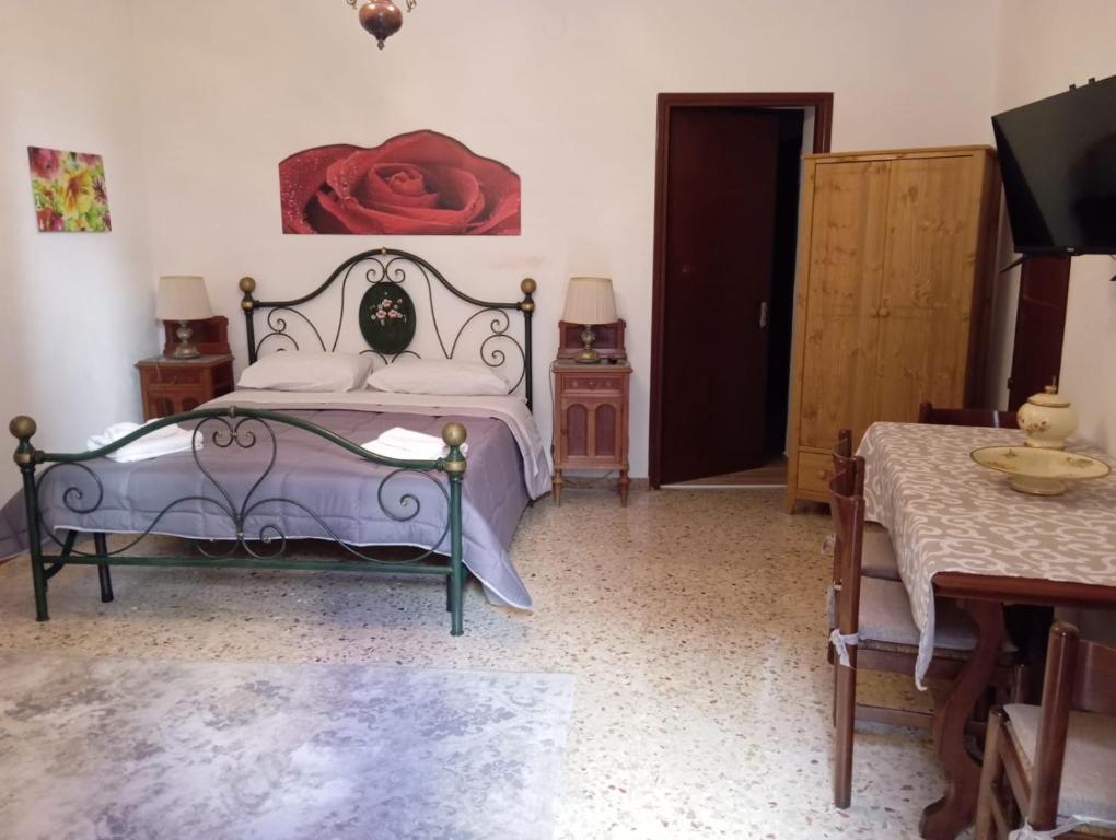 sypialnia z łóżkiem z czerwoną różą na ścianie w obiekcie ELICO A Sicily w mieście Sambuca di Sicilia