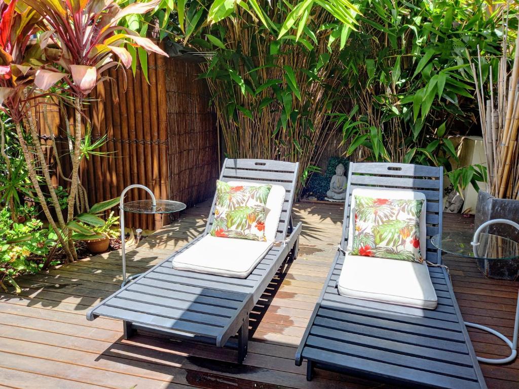zwei blaue Stühle mit Kissen auf einer Terrasse in der Unterkunft Palm Garden Villa-Apt - Tropical Oasis at Cronulla Beach in Cronulla