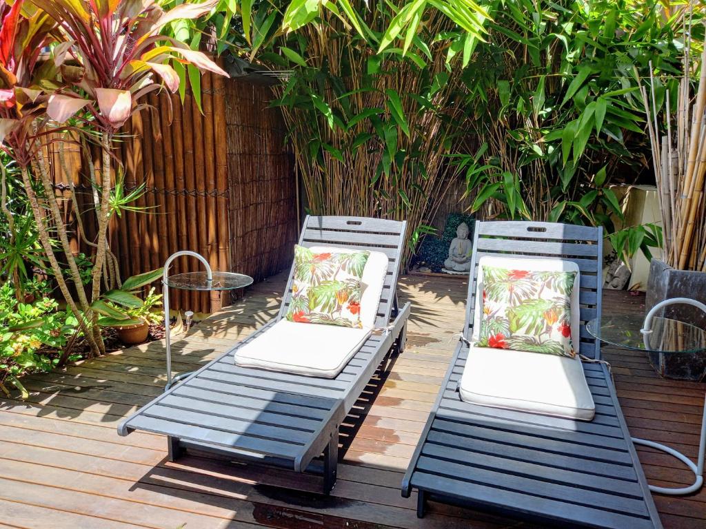 two blue chairs with pillows sitting on a deck at Palm Garden Villa-Apt - Tropical Oasis at Cronulla Beach in Cronulla