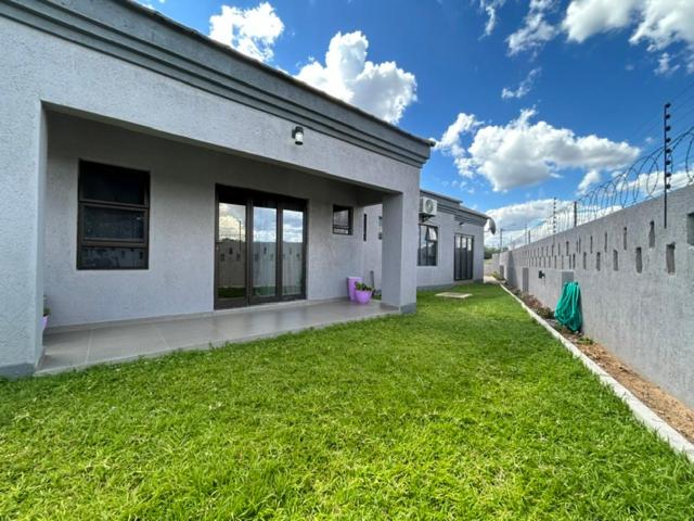 a building with a grass yard in front of it at Epic Springs Bed & Breakfast in Jwaneng