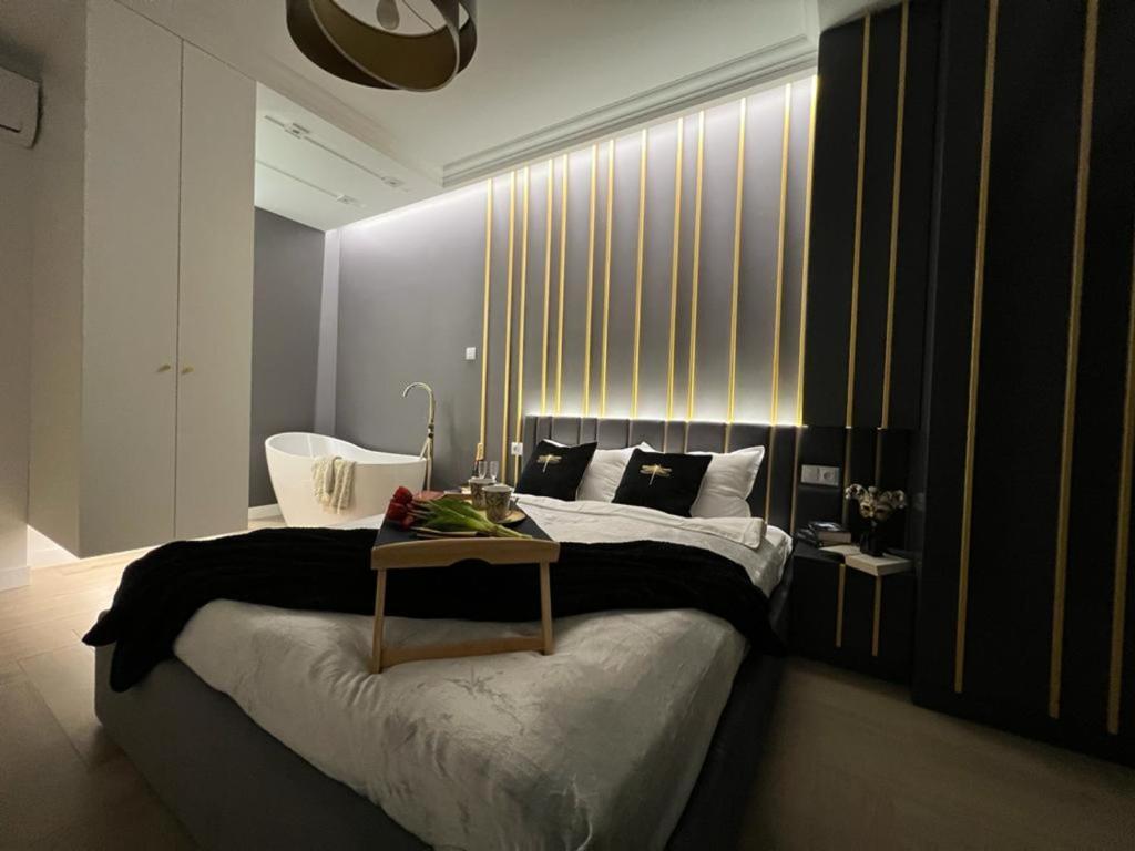 Un dormitorio con una cama grande y una mesa. en VipWarsawApartments pl Gold Mennica Residence, en Varsovia