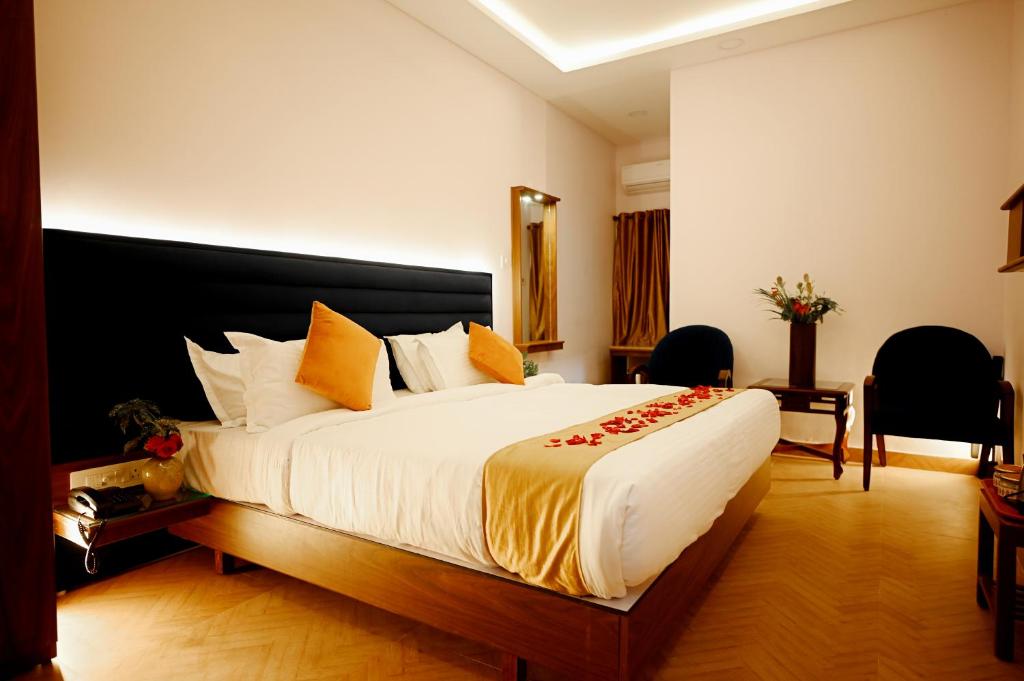 een slaapkamer met een groot bed in een kamer bij hotel ustav in Bolpur