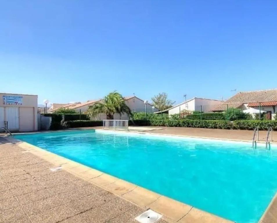une grande piscine bleue dans un immeuble dans l'établissement Maison dans résidence avec piscine 3 Chambres, à Saint-Cyprien