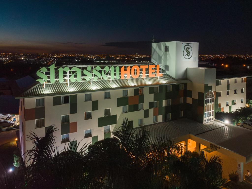 a building with a sign on top of it at night at Strassen Hotel in Goiânia