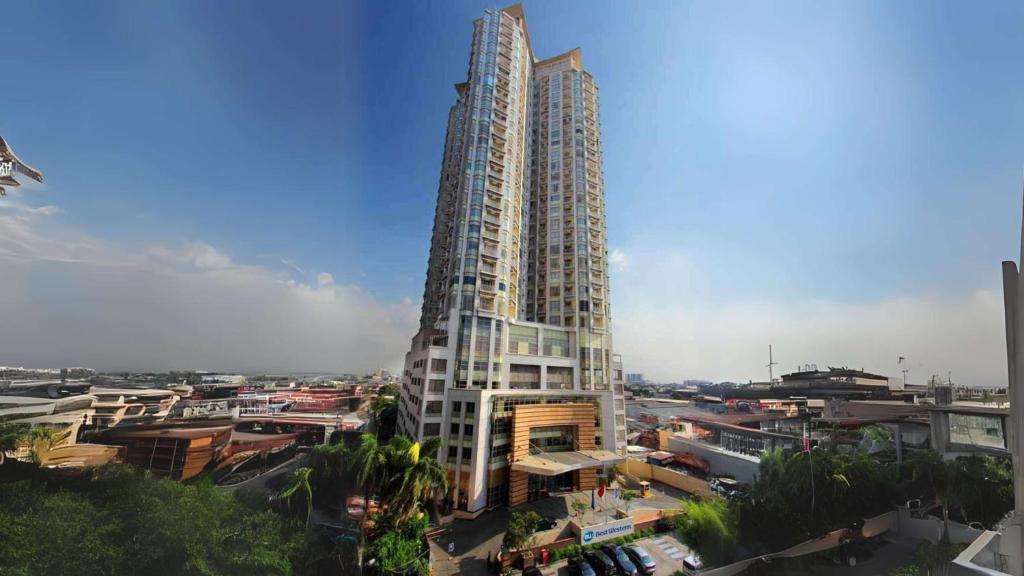 a large building with two tall towers in a city at Best Western Mangga Dua Hotel & Residence in Jakarta