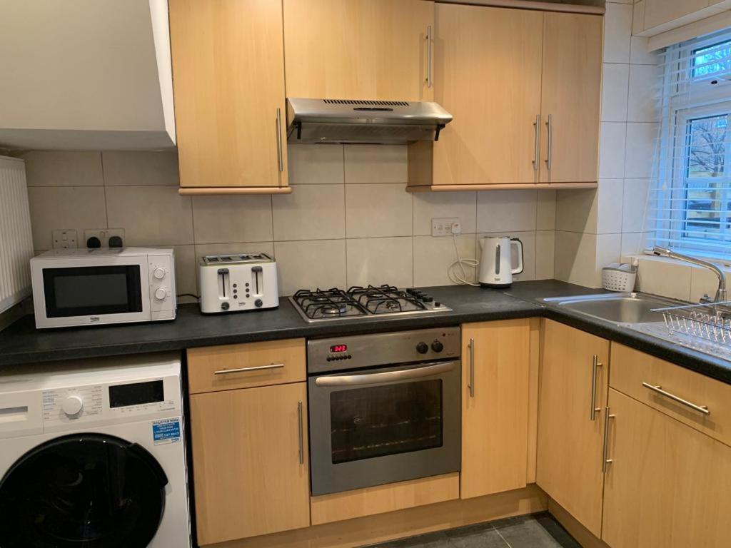 a kitchen with a stove and a microwave at TTSA- Essential 1 Bedroom Apt Balham-Free Parking in London
