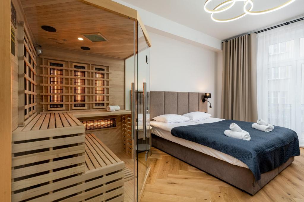 1 dormitorio con 1 cama y ducha acristalada en Luxury apartment with a sauna and bedroom with bath, en Cracovia