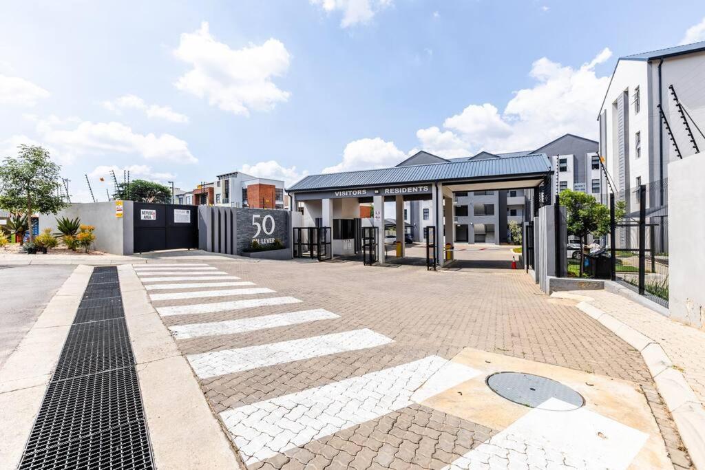 an empty street with a building in the background at Central Serenity @Midrand in Midrand
