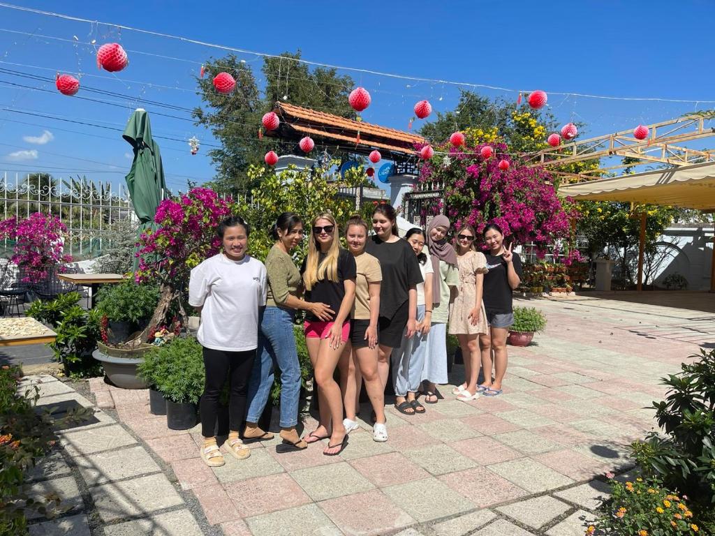a group of people standing in front of a garden at Lightly Homestay in Ho Coc