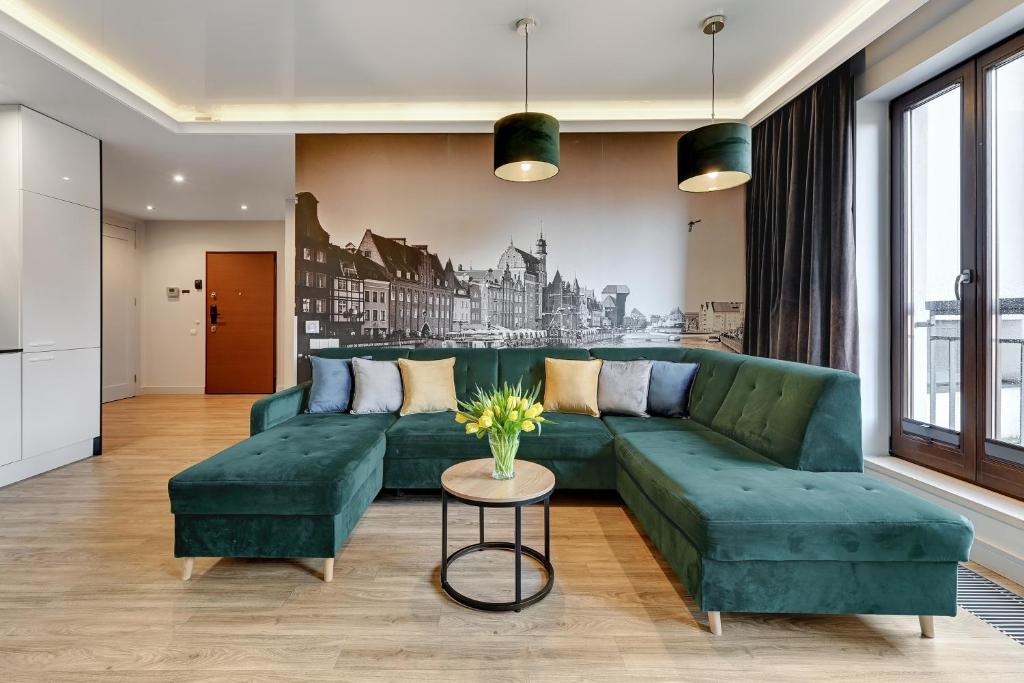 グダニスクにあるStaywin Apartmentsのリビングルーム(緑のソファ、テーブル付)