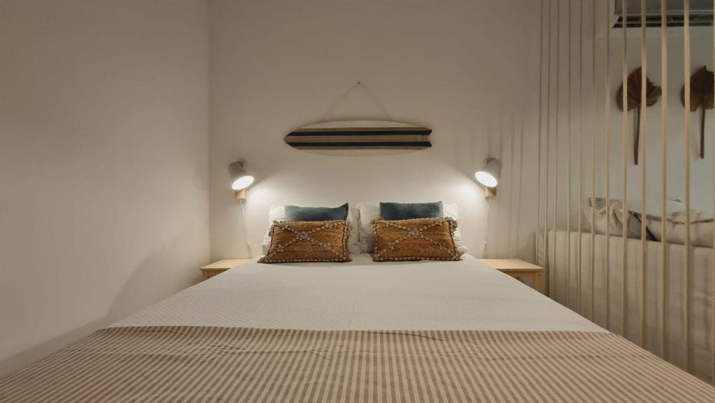 a bedroom with a large bed with two pillows at TAC - Sagres Studio in Sagres