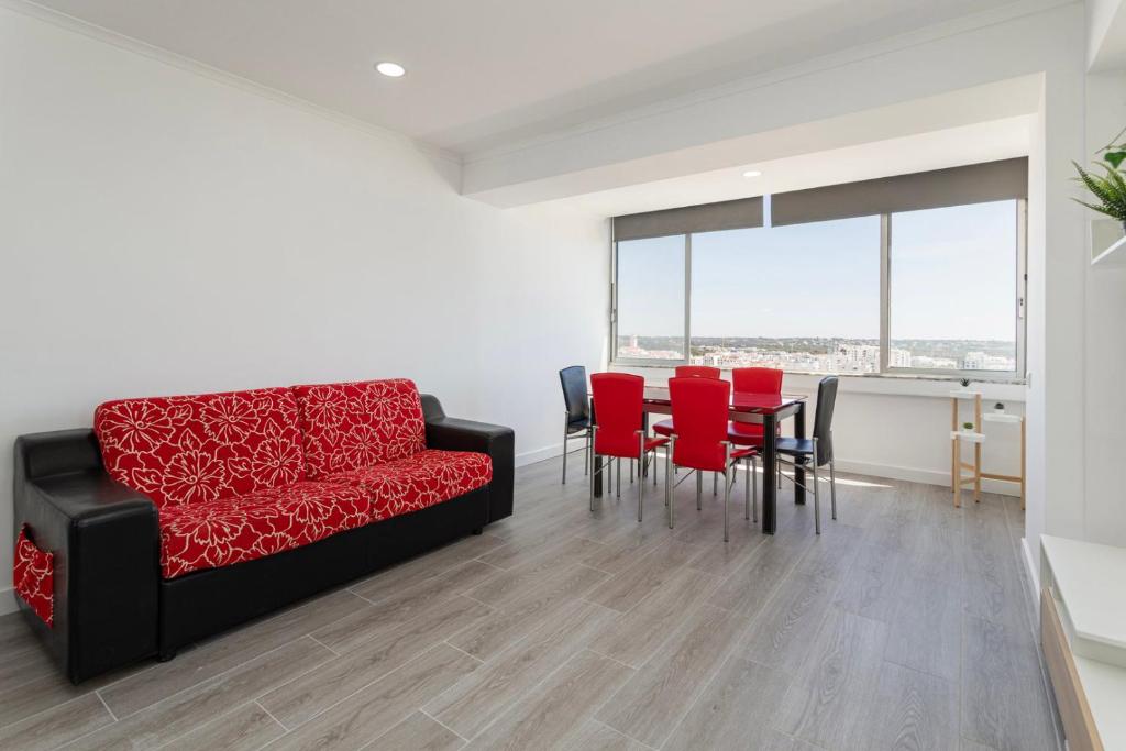 a living room with a red couch and red chairs at Quarteira SeaViews in Quarteira