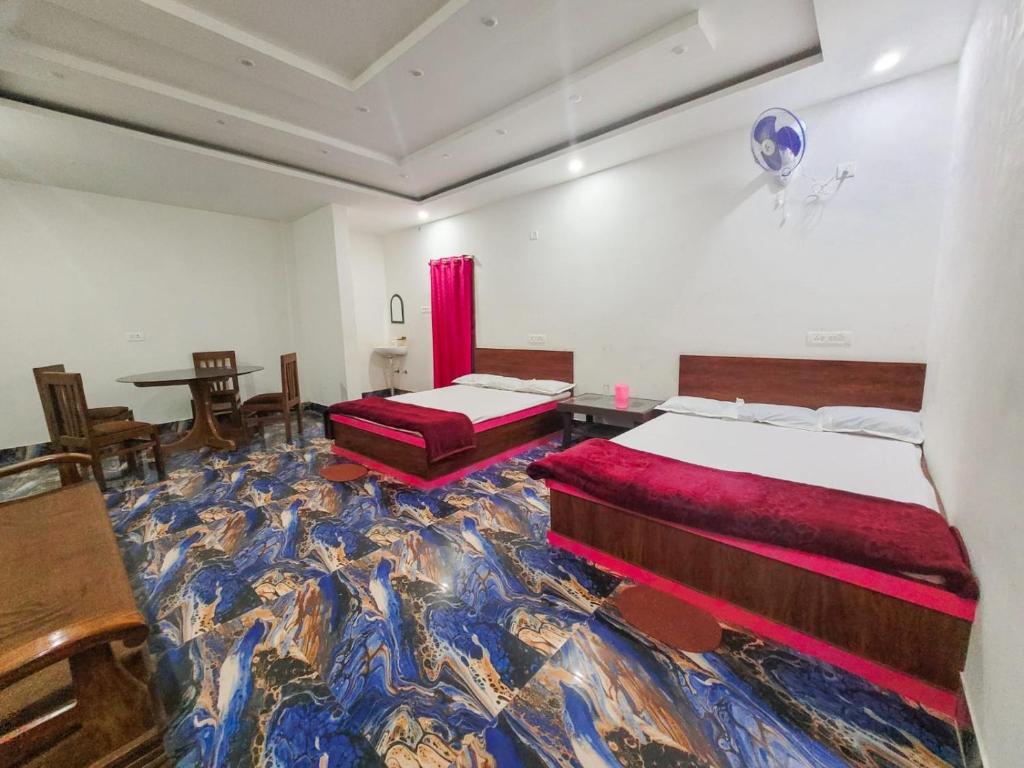 two beds in a room with a colorful carpet at Parinay Vatika Inn in Deoghar