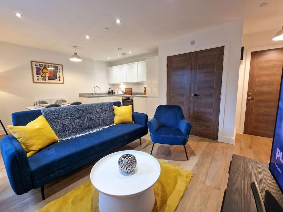 a living room with a blue couch and a table at Free Parking. Old Trafford Home in Manchester