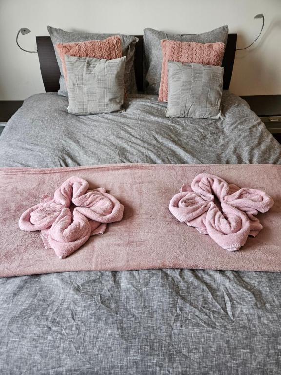 a bed with pink towels on top of it at Tuinen van Genta - Breda City in Breda