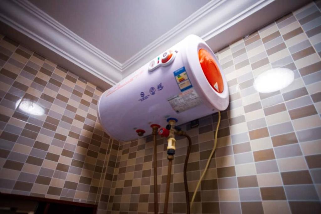 secador de pelo en la pared de un baño en Vedoko appart'hotel, en Cotonou
