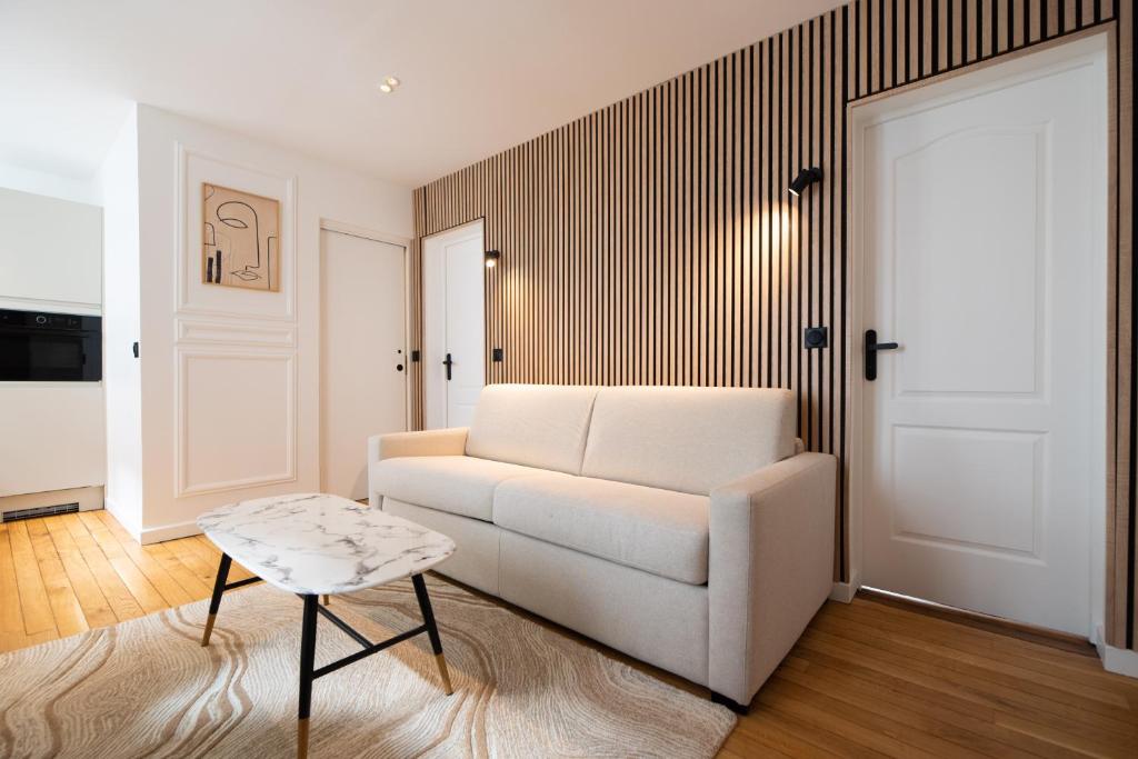 un salon avec un canapé blanc et une table dans l'établissement Lovely apartment Near Canal St Martin, à Paris