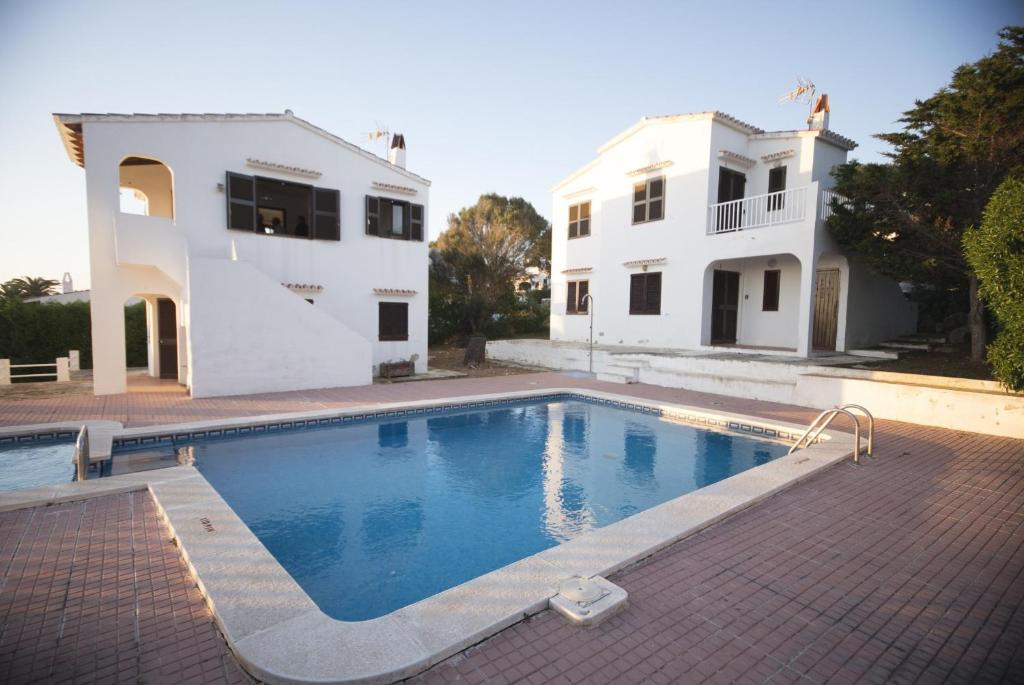 a swimming pool in front of a house at Binibeca Mar II in Binibeca