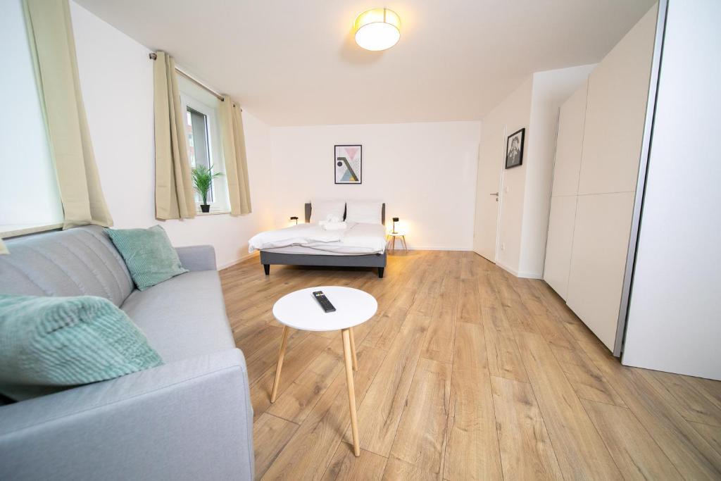 ein Wohnzimmer mit einem Sofa und einem Tisch in der Unterkunft Stylish Apartments - 71 m² - Zentral - 10 Min Messe in Düsseldorf