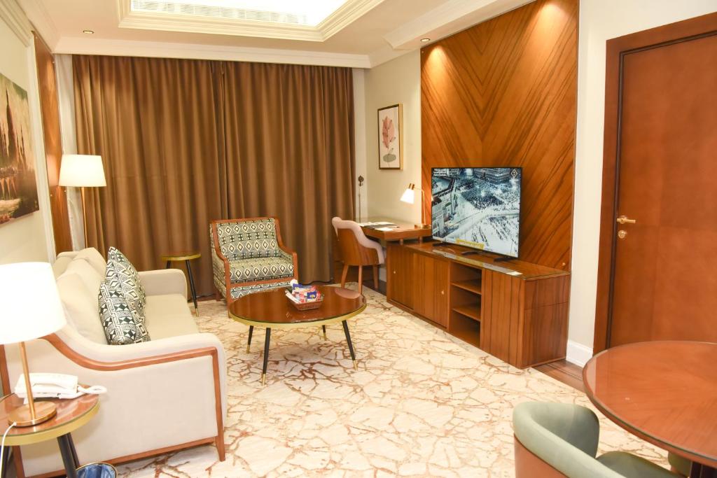 Habitación de hotel con TV y sala de estar. en Rose Bark - روز بارك en Hafr Al Batin