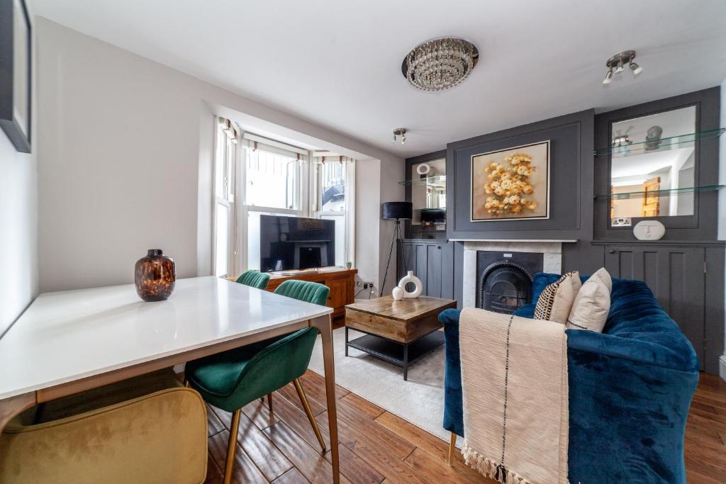 The Hammersmith Villa في لندن: غرفة معيشة مع أريكة زرقاء ومدفأة