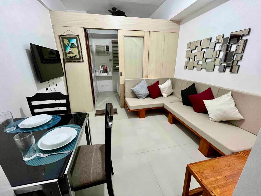 ein kleines Wohnzimmer mit einem Sofa und einem Tisch in der Unterkunft JC Condo, Jazz Bel-air Makati, Pool View in Manila