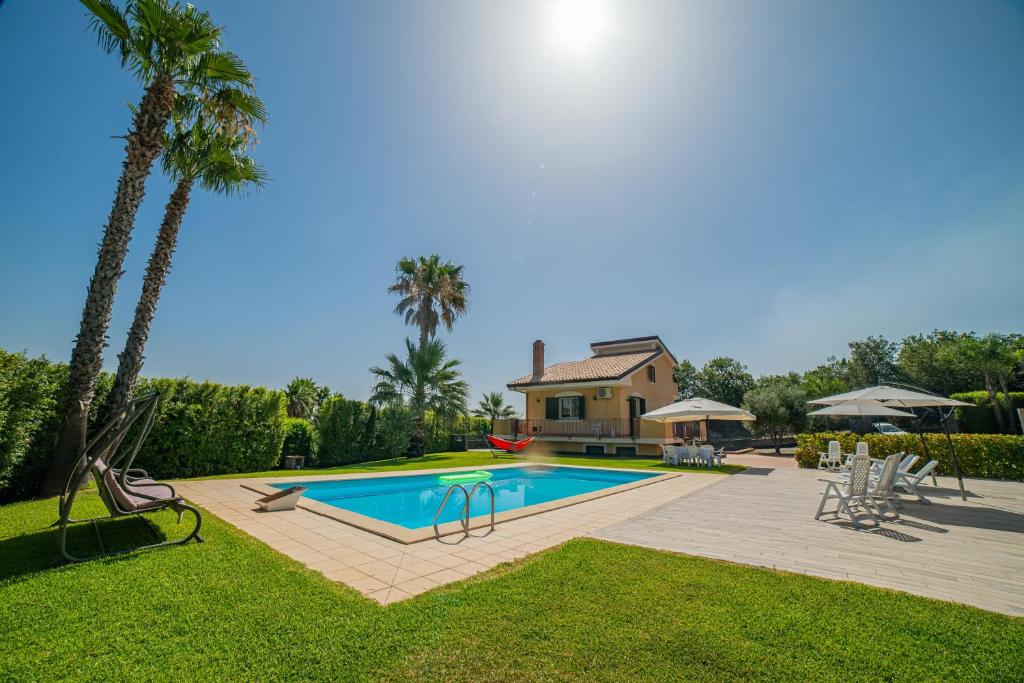 a house with a swimming pool in a yard at Villa Trinacria, Piedimonte Etneo in Presa